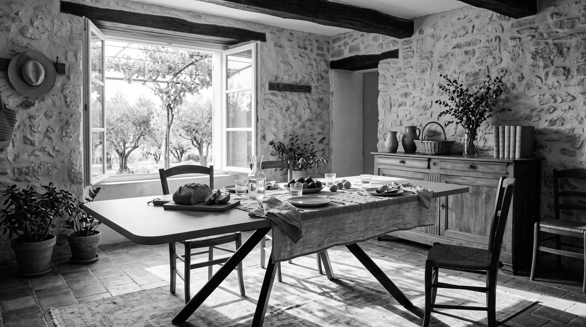 Table à manger extensible dans une salle à manger provençale ouverte sur les oliviers, en noir et blanc